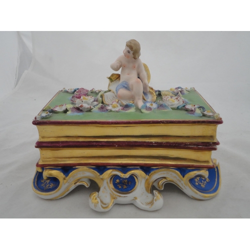205 - Continental ceramic desk stand with winged putti surmount and integral inkwells, decorated with encr... 
