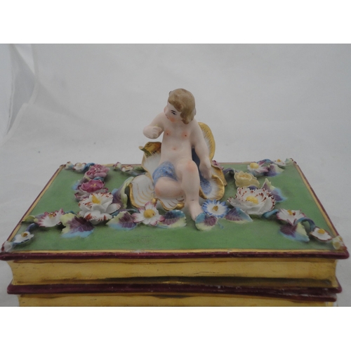 205 - Continental ceramic desk stand with winged putti surmount and integral inkwells, decorated with encr... 