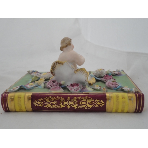 205 - Continental ceramic desk stand with winged putti surmount and integral inkwells, decorated with encr... 