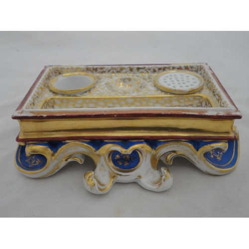 205 - Continental ceramic desk stand with winged putti surmount and integral inkwells, decorated with encr... 