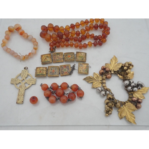 214 - Bag containing assorted decorative jewellery to include a cross pendant, Oriental-themed tiled brace... 
