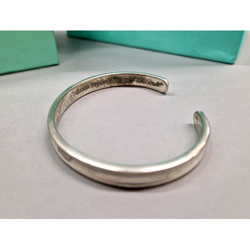 236 - Tiffany & Co silver stiff bangle dated 1999, with pouch, box, and bag