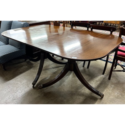 595 - Mahogany extending dining table raised on tripod legs & casters