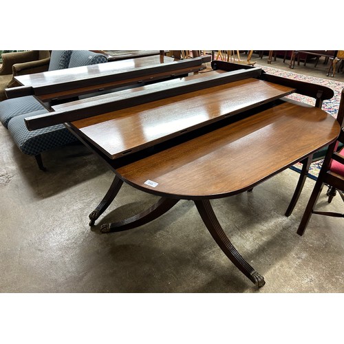 595 - Mahogany extending dining table raised on tripod legs & casters