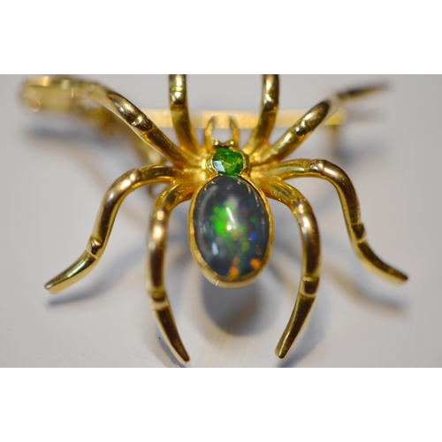 185 - Black opal spider brooch with open back, collet-set with a black opal bearing green and blue hue, on... 