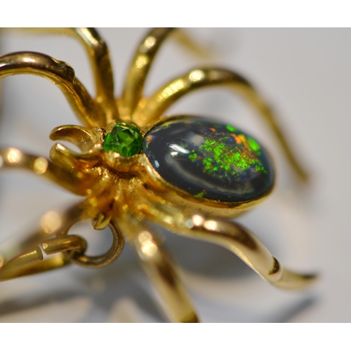 185 - Black opal spider brooch with open back, collet-set with a black opal bearing green and blue hue, on... 