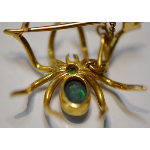 185 - Black opal spider brooch with open back, collet-set with a black opal bearing green and blue hue, on... 