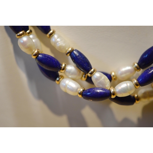 173 - Freshwater pearl and lapis necklace comprising three strands, approximately twenty pearls and lapis ... 