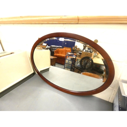 62 - Large oval mahogany wall mirror.