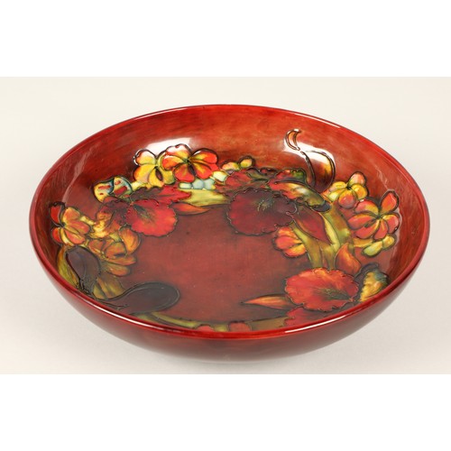 12 - Moorcroft pottery shallow flambé bowl in the orchid pattern, impressed marks and signed to the base ... 