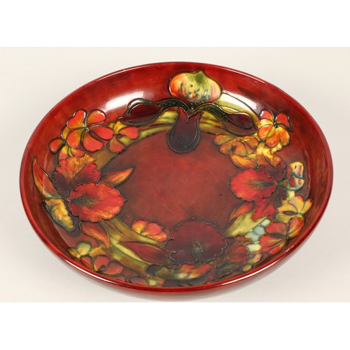 12 - Moorcroft pottery shallow flambé bowl in the orchid pattern, impressed marks and signed to the base ... 