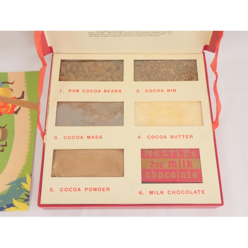 394 - A 1950s Nestle chocolate display case, outlining the various stages of chocolate production, along w... 