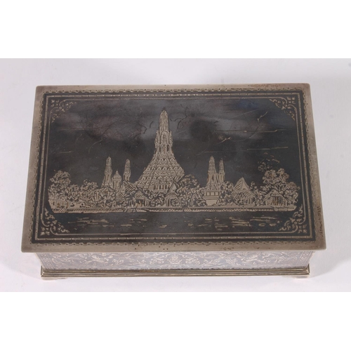 11 - Thai niello silver cigarette box, mid 20th century, the hinged lid decorated with a scene of Wat Pho... 