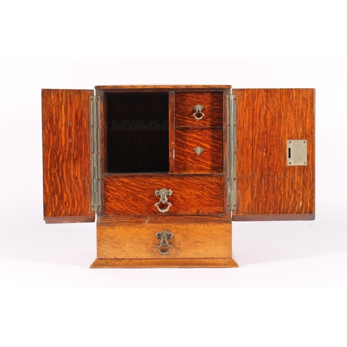 400 - Oak smoker's cabinet, early 20th century, the door opening to reveal drawers and fitted compartments... 