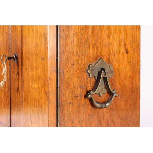 400 - Oak smoker's cabinet, early 20th century, the door opening to reveal drawers and fitted compartments... 