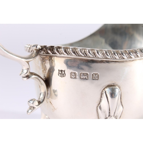 21 - George V silver sauce boat of plain form with reeded edge and raised on three shell headed paw feet ... 