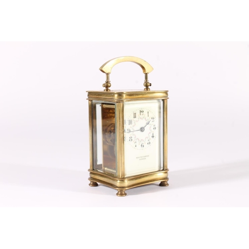 412 - French brass carriage clock, early 20th century, of concave form with shaped hoop handle, the white ... 