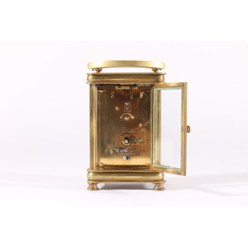 412 - French brass carriage clock, early 20th century, of concave form with shaped hoop handle, the white ... 