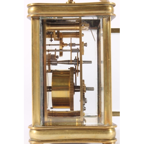 412 - French brass carriage clock, early 20th century, of concave form with shaped hoop handle, the white ... 