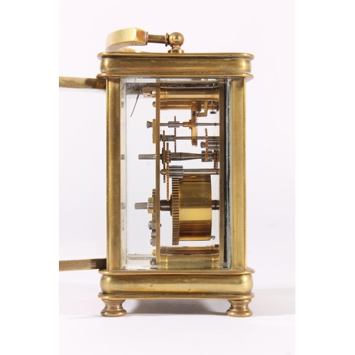 412 - French brass carriage clock, early 20th century, of concave form with shaped hoop handle, the white ... 