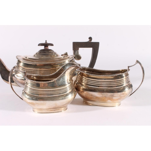 5 - George V silver three-piece tea set, the teapot with angular ebonised handle and ribbed body, the mi... 