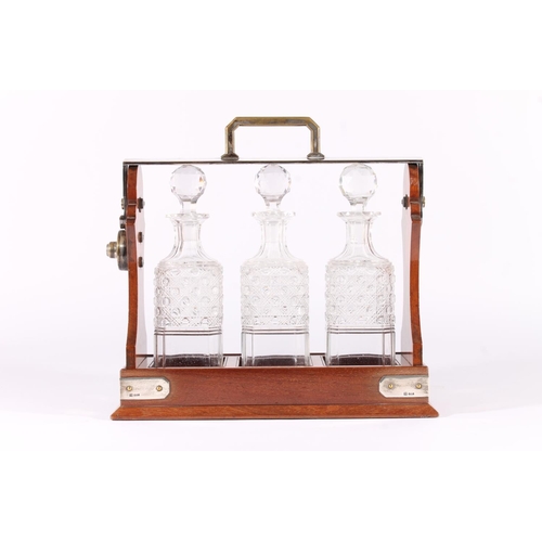 416 - Early 20th century oak and silver plated Tantalus, holding three hobnail cut glass decanters, the si... 