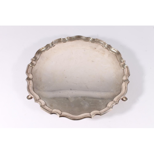 66 - George V silver salver with piecrust edge raised on three scroll supports with pad feet, hallmarked ... 