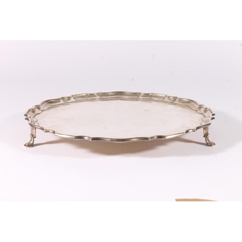 66 - George V silver salver with piecrust edge raised on three scroll supports with pad feet, hallmarked ... 