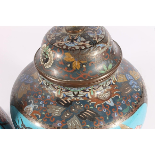 521 - Pair of Japanese cloisonne urns, Meiji period, of globular form with banded globe finial on a dome c... 