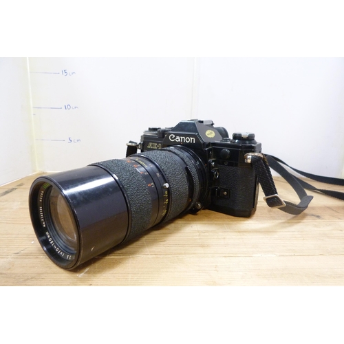 212 - Canon AE-1 camera with attached Tamron micro lens, with spare Canon lenses and accessories in fitted... 