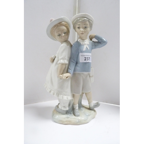 237 - Lladro figure group modelled as a boy and girl couple, and two Lladro child angel figures, one playi... 