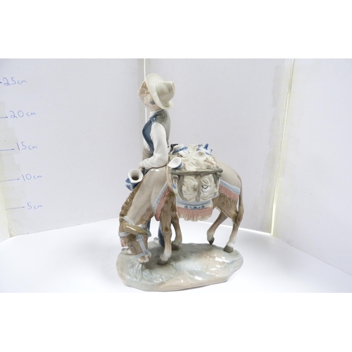 244 - Lladro figure group modelled as a peddler with wares on a donkey.