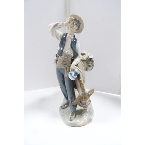 244 - Lladro figure group modelled as a peddler with wares on a donkey.