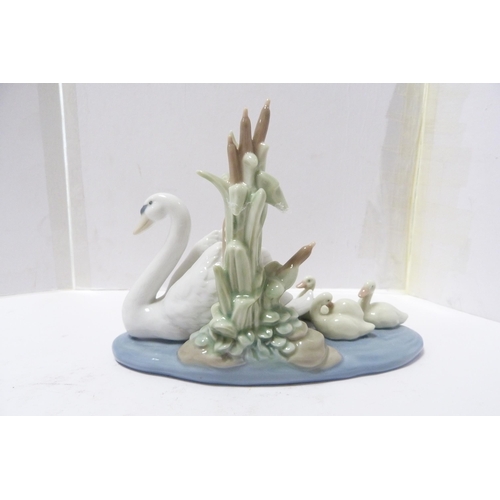 246 - Two Lladro figure groups modelled as a frog on a lily pad and a swan with cygnets.  (2)