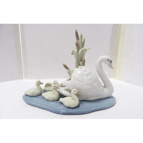 246 - Two Lladro figure groups modelled as a frog on a lily pad and a swan with cygnets.  (2)