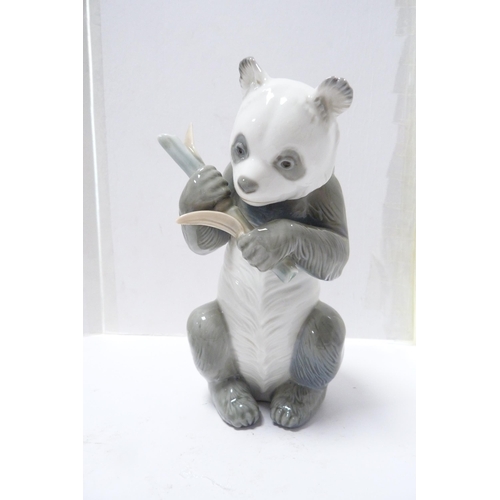 247 - Two Nao animal figures modelled as a panda holding shoots and a dog, also another Nao group of three... 