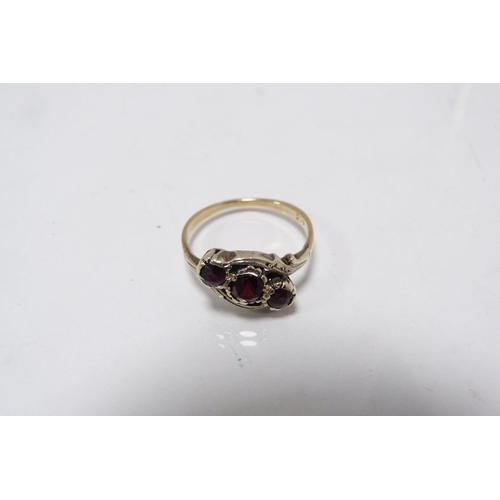 293 - 9ct gold garnet three-stone lady's ring, 2.9g gross.