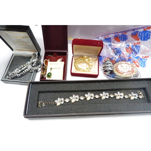 324 - Box of costume jewellery to include bead necklaces, brooches, wristwatches etc., also a brush set.