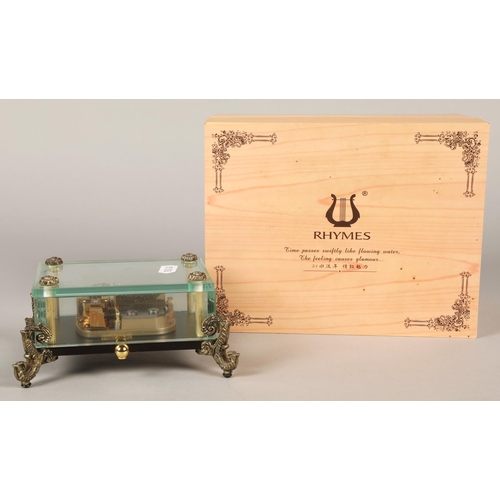 242 - Rhymer musical casket on scroll supports, in fitted box.