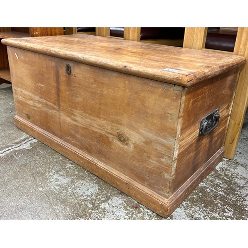 593 - Large pine storage chest containing small quantity of assorted linens, and a pine gavel