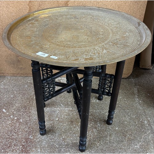 657 - Brass tray table top in Ancient Egyptian design with folding hardwood base