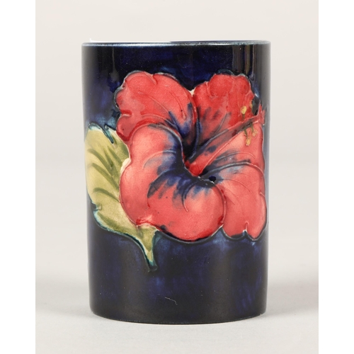 26 - Moorcroft small cylindrical vase, the blue ground decorated with poppies 7cm, paper label to base an... 