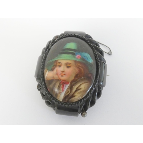 39 - Carved Whitby jet brooch with painted porcelain panel of a Tyrolean boy.