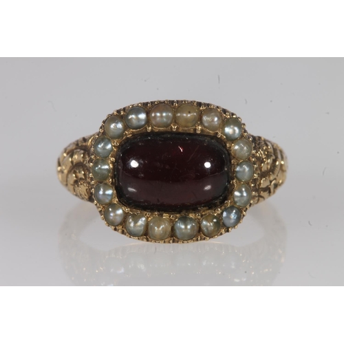 132 - Georgian yellow metal, garnet and seed pearl ring, the cabochon garnet within a halo of split pearls... 