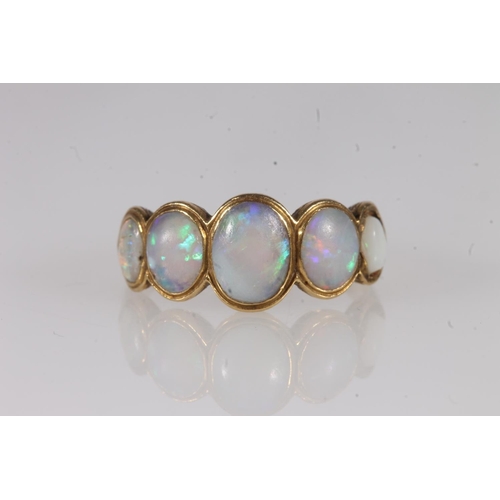 139 - Early 20th century yellow metal and opal five stone ring, the graduated cabochon opals bezel set wit... 