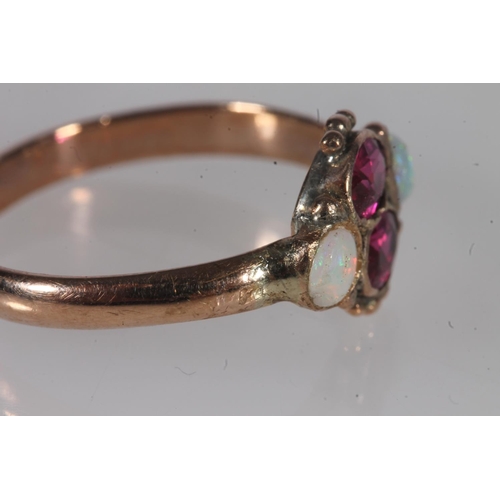 191 - Early 20th century yellow metal pink stone and opal ring, the oval cut pink stones flanked by caboch... 