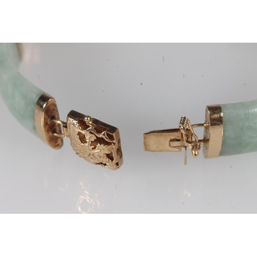 219 - Chinese 14ct gold and jade bangle, the jade segments linked by openwork gold dragons, total length 1... 