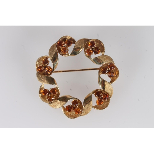 238 - 18ct gold twisted round brooch set with round cut amber coloured stones, 11.2g, 4.1cm wide.