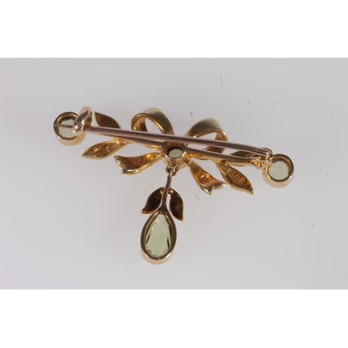 241 - Edwardian 15ct gold peridot and seed pearl bar brooch, the bow form openwork frame studded with spli... 