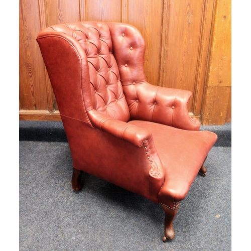 642 - Chesterfield type wingback armchair, the button backed chair upholstered in burgundy on cabriole leg... 